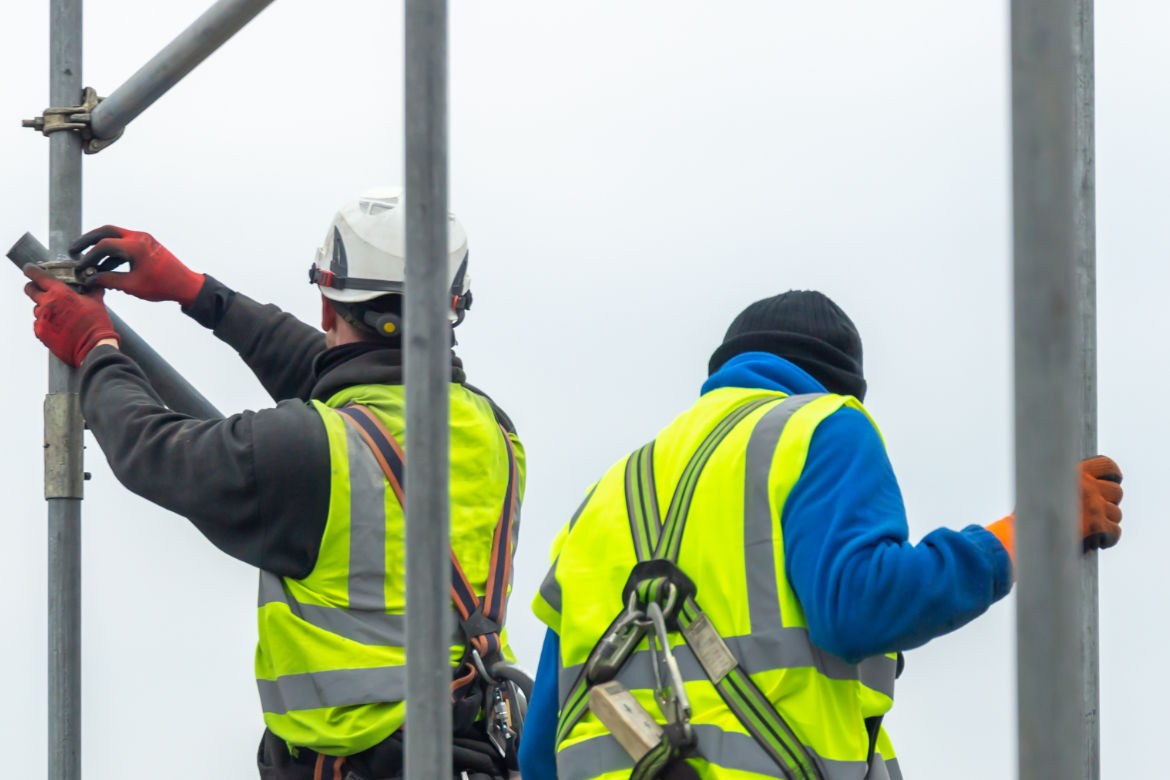 construction worker installing scaffolding